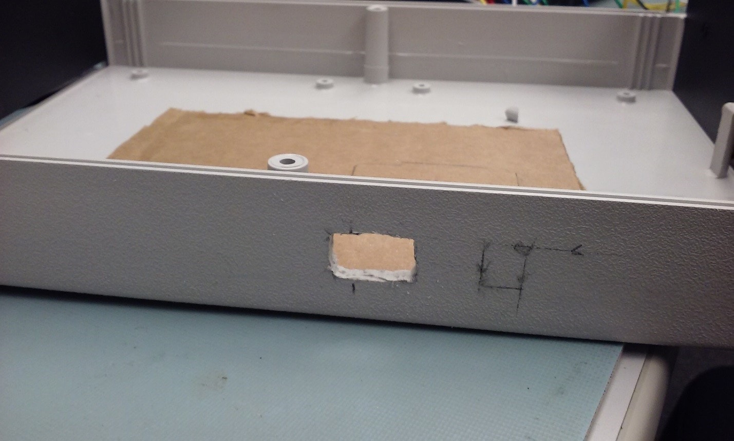 The USB port hole and a marking for the power port.