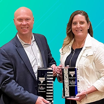Two Mouser representatives, each posing with a trophy
